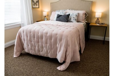 Cozy bedroom setup with pink quilt and lamps