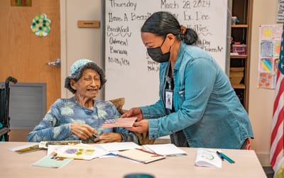 A senior resident interacting with a staff member