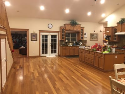 Spacious kitchen area with wooden floors and cabinets