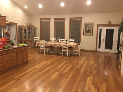 Brightly lit dining area with wooden floors and a large table