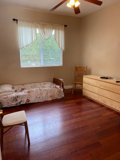 A private resident room with a bed and dresser