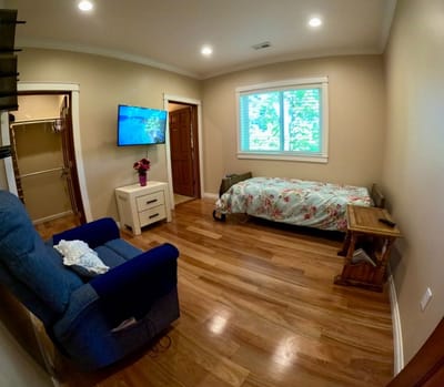 Interior view of a private resident room with a bed and chair