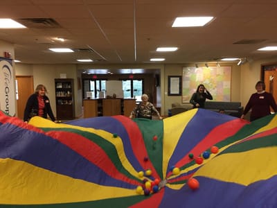Residents participating in a colorful activity indoors