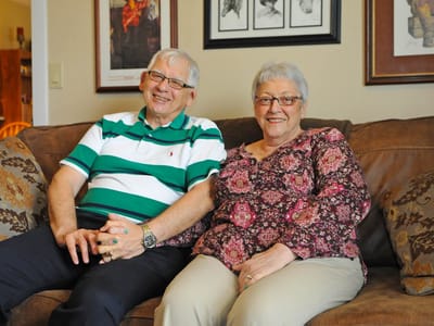 Two smiling residents sitting together on a couch