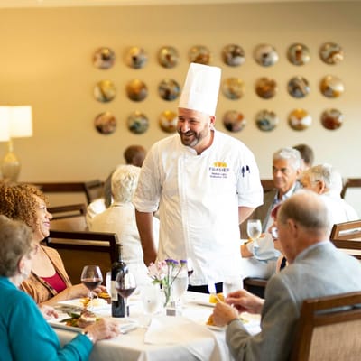 Chef serving food to residents in the dining area
