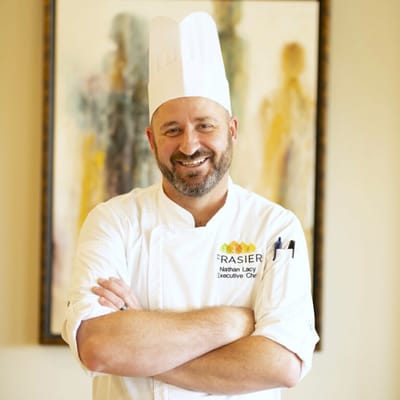 Executive chef smiling in a well-lit kitchen