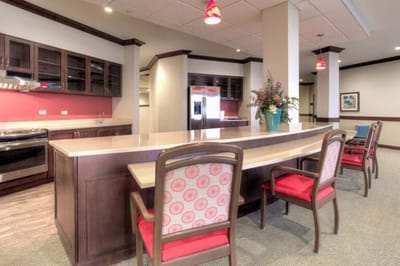 Brightly lit common area with kitchen and seating