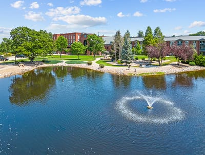 Aerial view of a senior living facility by a pond