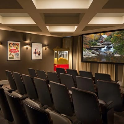 A cozy movie theater with seating and a popcorn machine