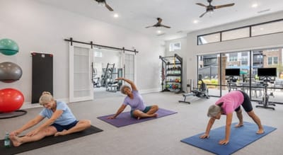 Residents participating in a gentle yoga class in the activity room