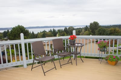 Balcony view with chairs and flowers overlooking a scenic landscape