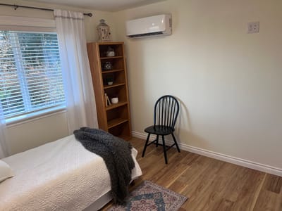A simple, well-lit resident bedroom with furnishings