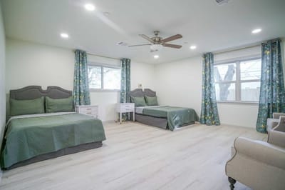 Bright twin room with two beds and floral curtains