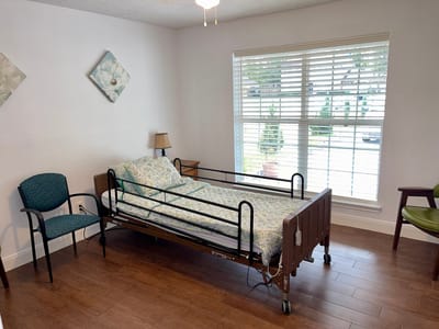 Empty resident room with a hospital bed and seating