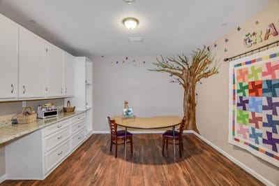 Bright activity room with a tree mural and table