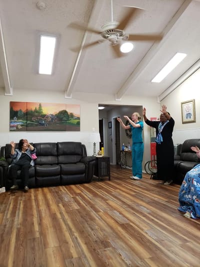 Residents and staff engaging in a lively activity in the common area