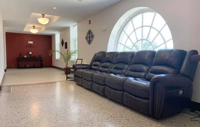 Interior hallway with a leather couch and decorative window