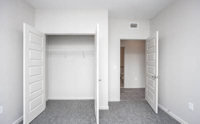 Empty resident room with two doors and carpeted floor