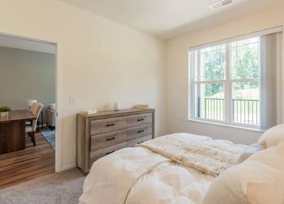 Bright, furnished bedroom looking into living area