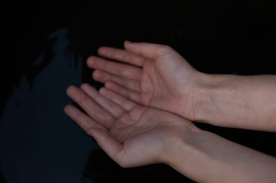 Two open hands against a dark background