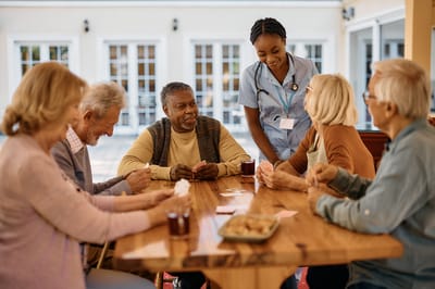 Residents enjoying a game with a staff member in a common area