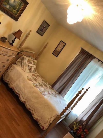 Cozy bedroom with a quilt and decorative lamp