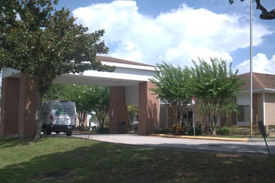 Building entrance with a van parked outside