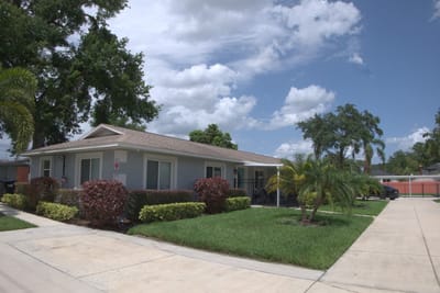 Exterior view of a senior living facility with gardens