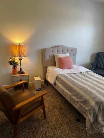Cozy private resident room with a bed and armchair