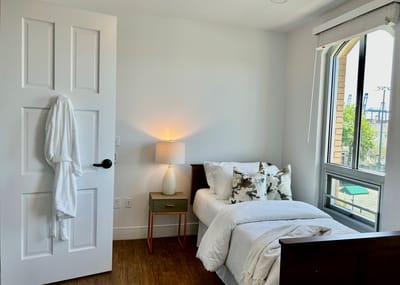 Cozy resident room with a bed and bedside lamp