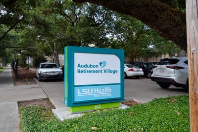 Signage for Audubon Retirement Village in a landscaped area