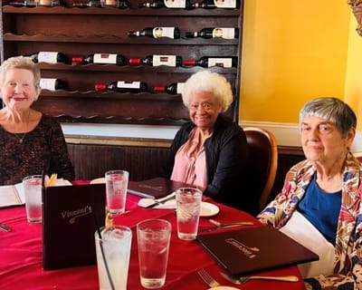 Three residents enjoying lunch at a dining table
