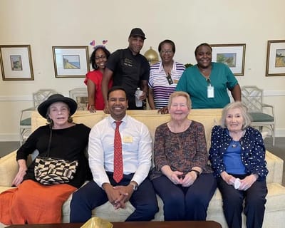 Residents and staff smiling together in a common area