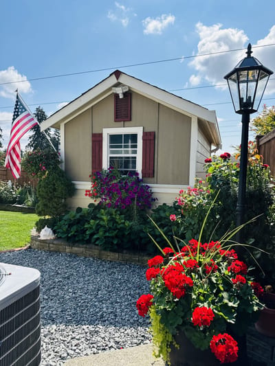 Charming exterior of a home with flowers and an American flag