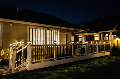 Well-lit outdoor deck with lanterns and patio umbrella