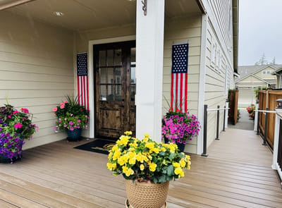 Entrance of a senior living facility with flowers and flags