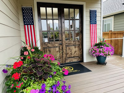Welcoming entrance with flowers and flags.