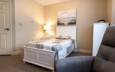 Cozy resident room with a bed and chair