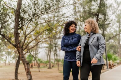 Two women walking together in a park