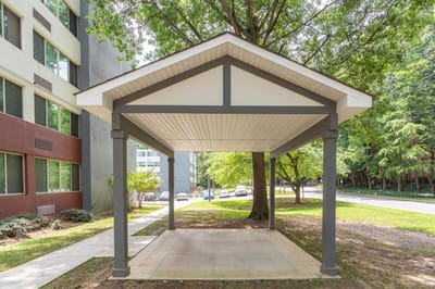 Covered outdoor seating area surrounded by trees