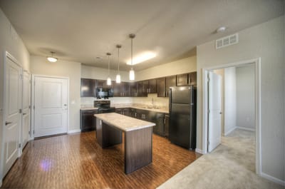 Modern kitchen area with dark cabinets and appliances