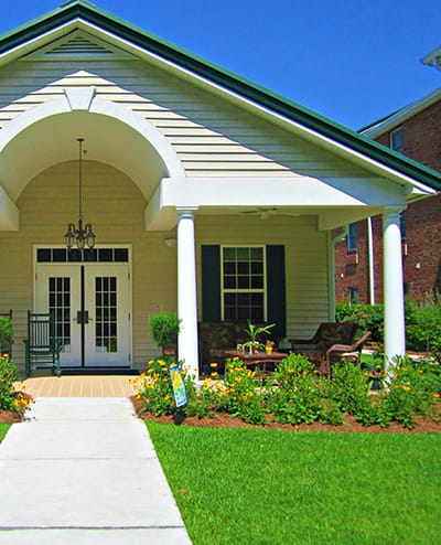 Front entrance of a senior living facility with landscaped garden