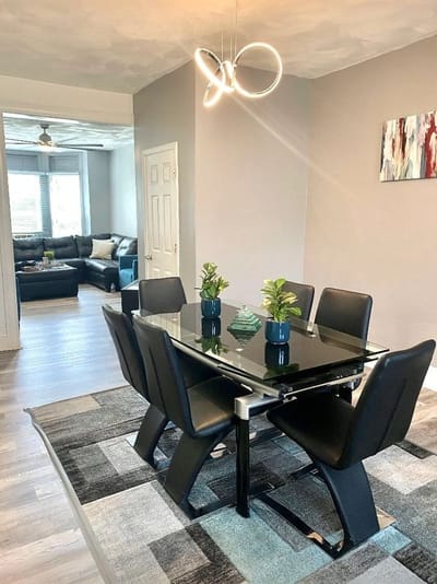 A modern dining room with a glass table and black chairs