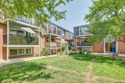 View of multiple apartments with balconies and green space