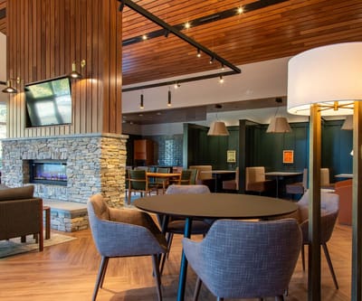 Bright common area with stone fireplace and seating