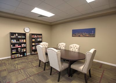 Bright common area with a table and bookshelves