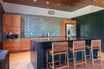 Modern kitchen interior with wooden cabinetry and bar stools
