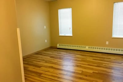 Empty room with windows and wooden flooring