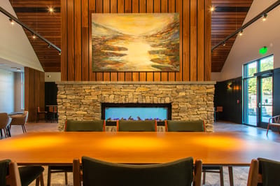 Interior view of a dining area with stone fireplace and artwork
