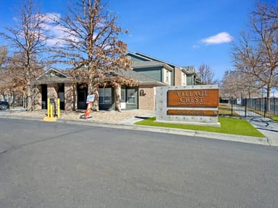 Exterior view of Village Crest Apartments with signage